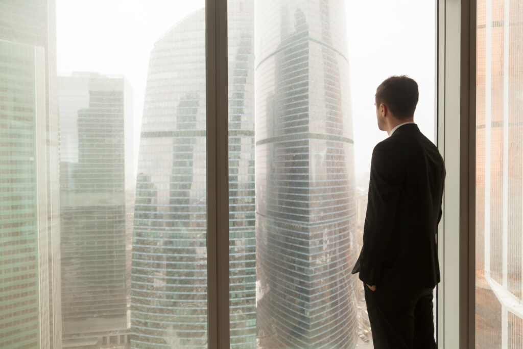 Cadre regardant les tours d'affaires depuis son bureau, profil visa Long-Term Resident (LTR) Thaïlande